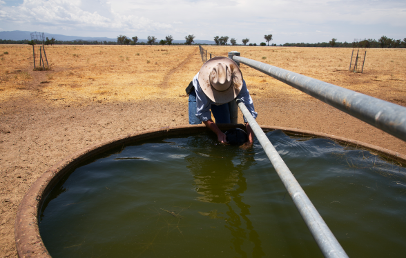 Farmer fixing a water trough in drought NSW Australia