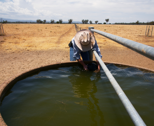 Farmer fixing a water trough in drought NSW Australia