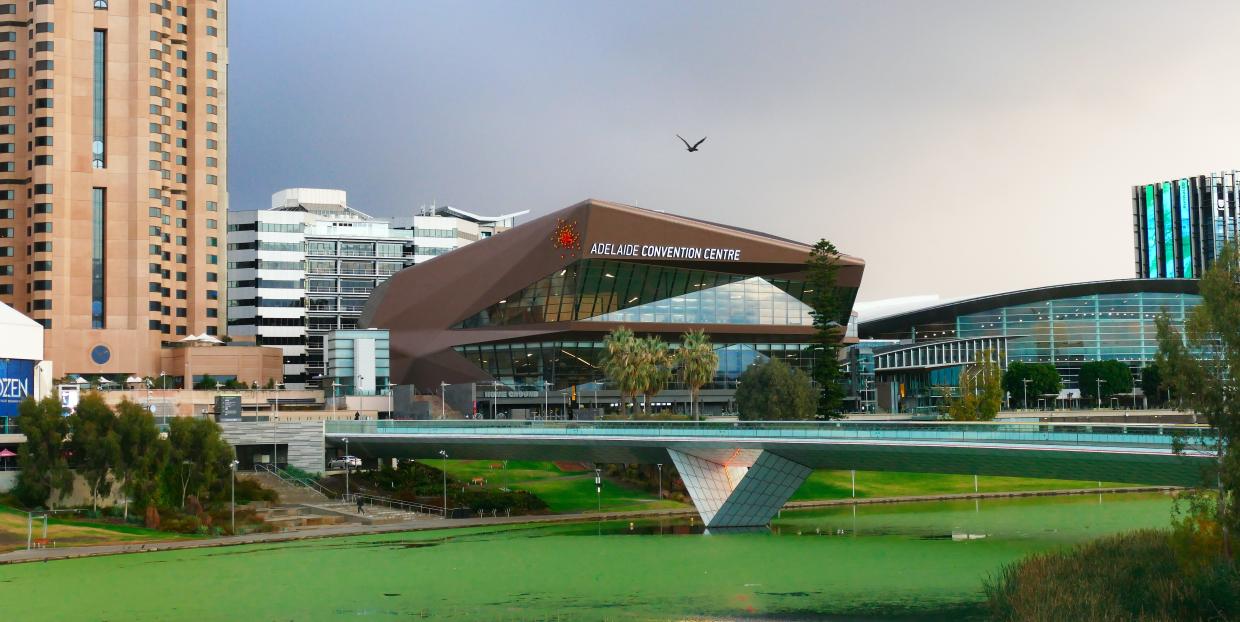 A landscape photo with the Adelaide Convention Centre behind a bridge over a river