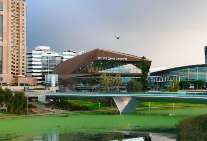 A landscape photo with the Adelaide Convention Centre behind a bridge over a river